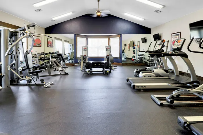 Modern fitness center featuring state-of-the-art exercise equipment and a spacious, well-lit workout area.