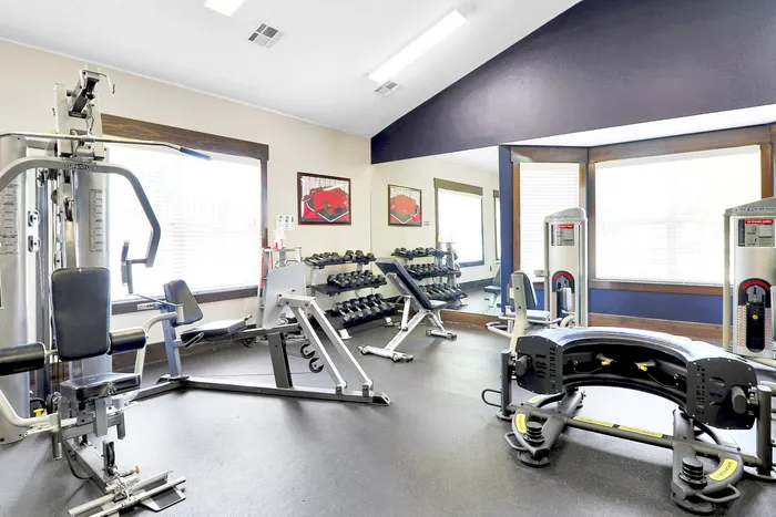 Spacious, well-lit fitness center equipped with modern gym machines and free weights, perfect for an invigorating workout.