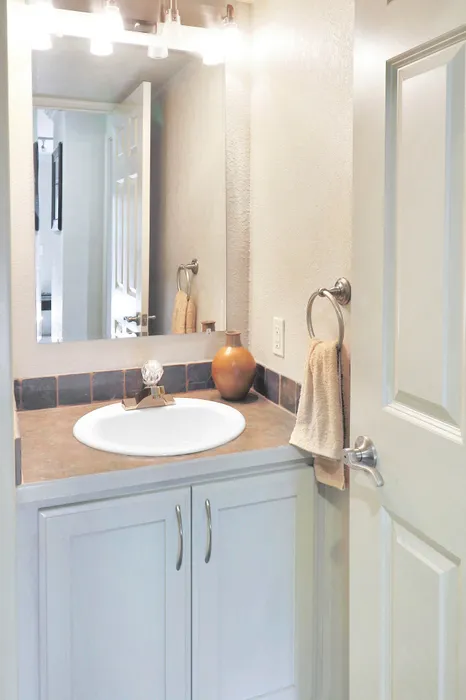 Elegant bathroom design featuring a chic vanity with a modern sink, ambient lighting, and stylish fixtures enhanced by natural stone accents.