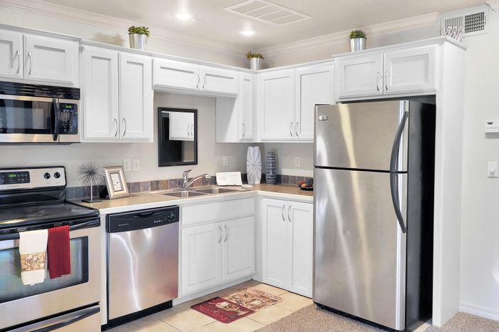 Modern kitchen with sleek stainless steel appliances, elegant white cabinetry, and inviting cozy decor.