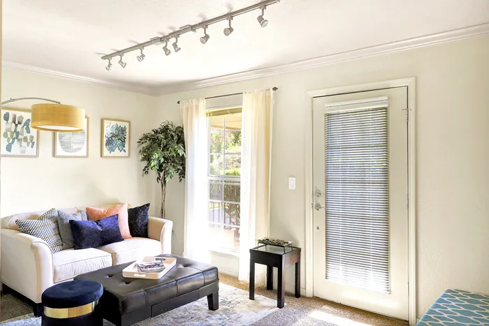 Bright and inviting living room with plush seating, elegant decor, and abundant natural light through large windows.