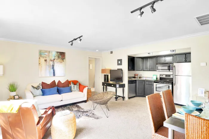 Bright and inviting modern living room with elegant decor, featuring an open-concept layout with a sleek kitchen and comfortable seating area.