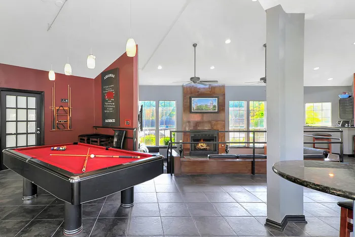 Modern, inviting lounge with a sleek billiards table, cozy fireplace, and vibrant lighting.