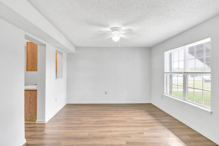 Bright and airy living space with hardwood flooring and large windows offering abundant natural light.