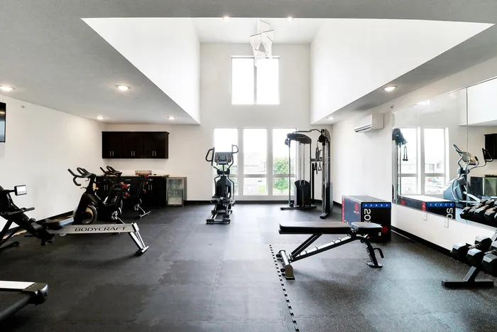 Modern fitness center with state-of-the-art equipment, bright natural lighting, and spacious workout area.