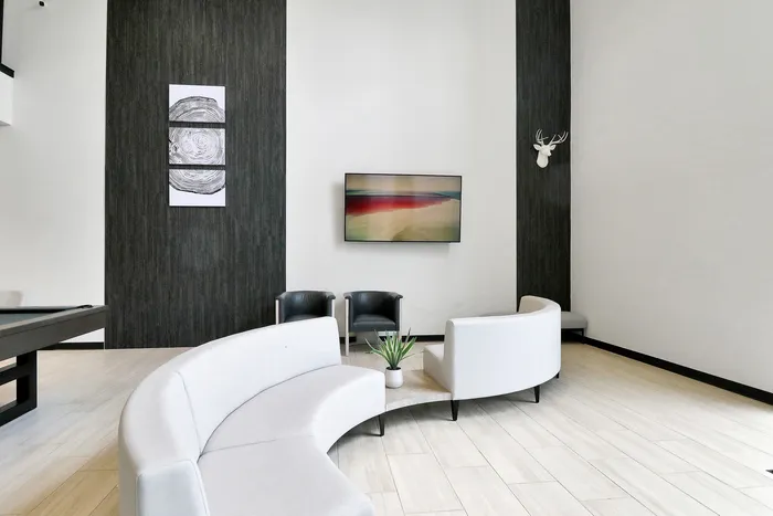 Sophisticated modern living room featuring sleek curved seating, artistic wall decor, and elegant plants, offering a stylish and inviting atmosphere.