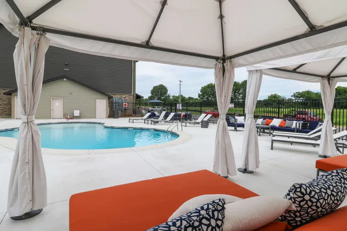 Luxurious outdoor pool area with cozy cabanas and stylish lounge chairs perfect for relaxation.