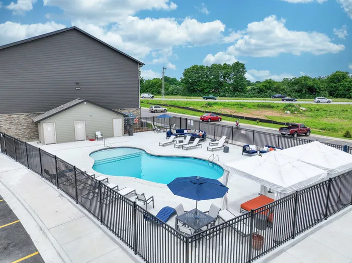 Inviting outdoor pool area with elegant seating and umbrellas, perfect for relaxation and leisure.