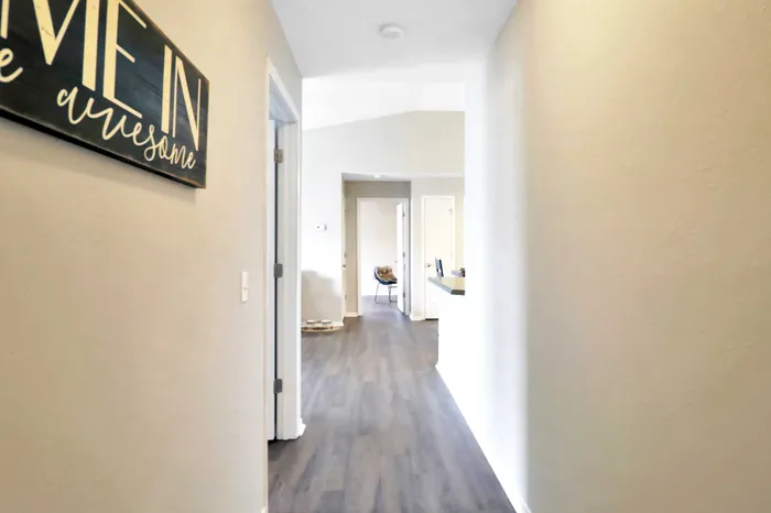 Inviting apartment hallway with elegant flooring, leading to a bright and spacious living area.