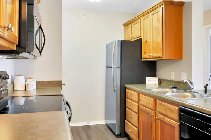 Charming kitchen with modern appliances, sleek countertops, and ample wooden cabinetry for a cozy cooking experience.