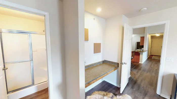 Inviting apartment interior with modern bathroom, functional workspace, and sleek kitchen design.