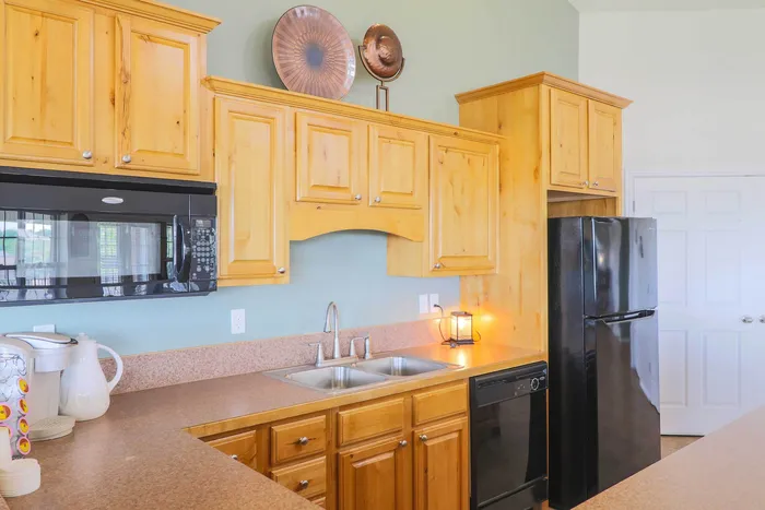 Charming kitchen featuring warm wooden cabinets, modern appliances, and a sleek countertop, perfect for culinary inspiration.