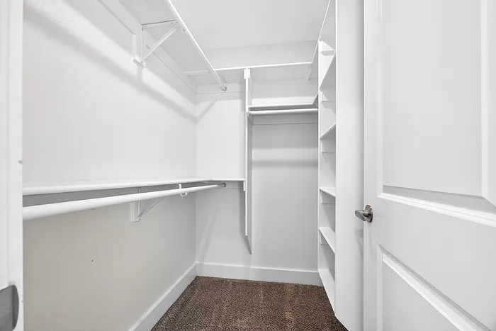 Spacious walk-in closet with ample shelving and hanging space, perfect for organized living.