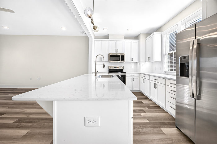 Contemporary kitchen with sleek white cabinets, modern appliances, and an expansive island perfect for entertainment.