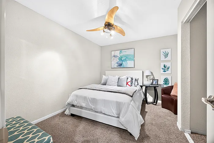 Cozy bedroom featuring elegant decor, modern ceiling fan, and plush bedding in a serene setting.