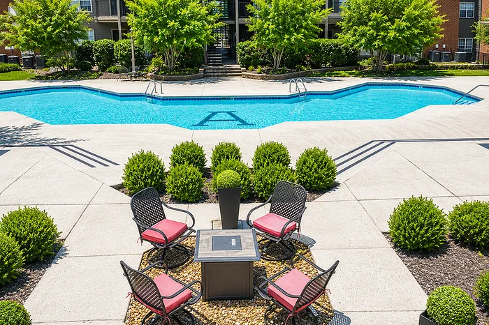 Inviting outdoor pool area with relaxing seating and vibrant greenery, perfect for leisurely afternoons.
