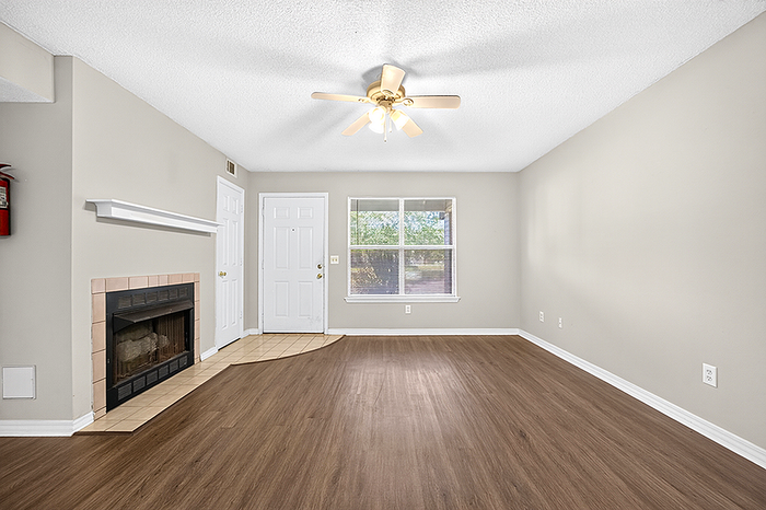 Bright, open living space with elegant wood flooring, cozy fireplace, and ample natural light.