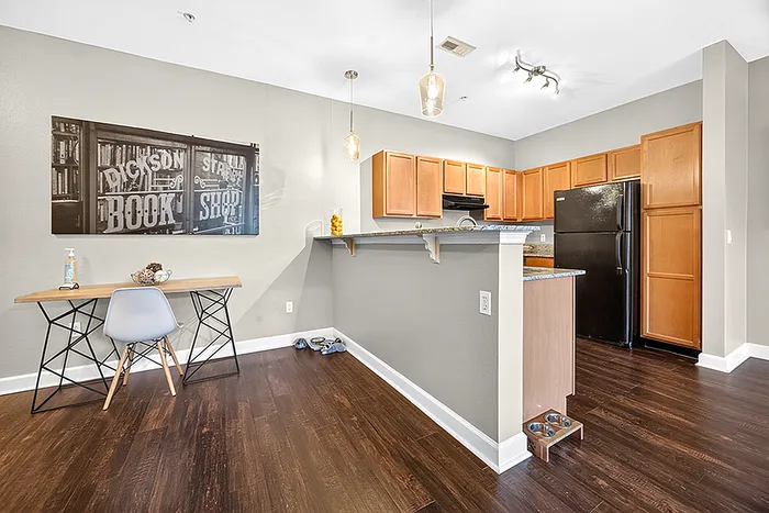 Chic modern kitchen with sleek cabinetry, polished countertops, and cozy workspace adjacent to open-concept dining area.