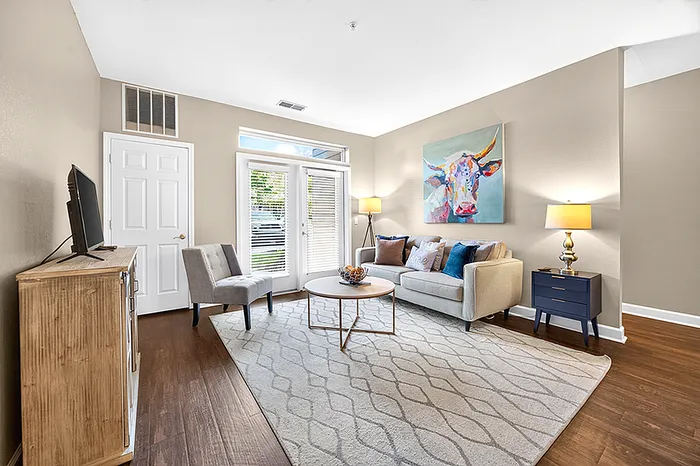 Inviting living room with chic decor, a cozy sofa, and natural light streaming through elegant glass doors.