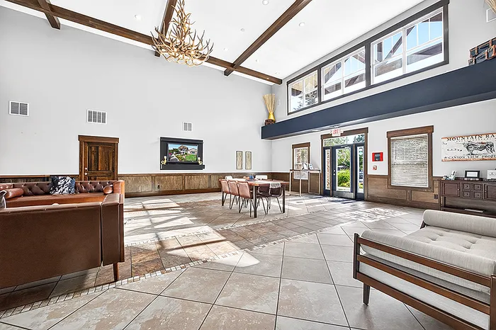 Bright and spacious communal lounge with elegant furnishings, large windows, and modern decor.
