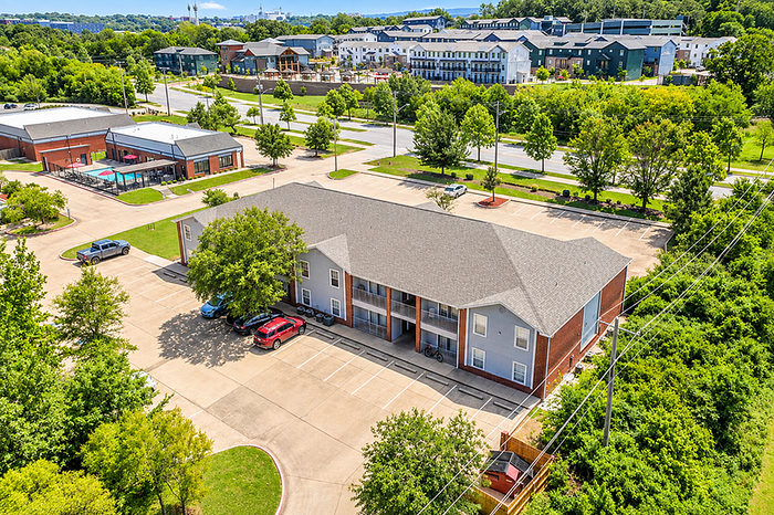 Charming residential complex with modern architecture, lush green surroundings, and ample parking spaces.