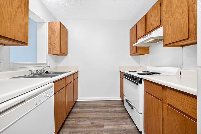 Charming kitchen with sleek wooden cabinets, modern appliances, and a stylish countertop, perfect for culinary creativity.