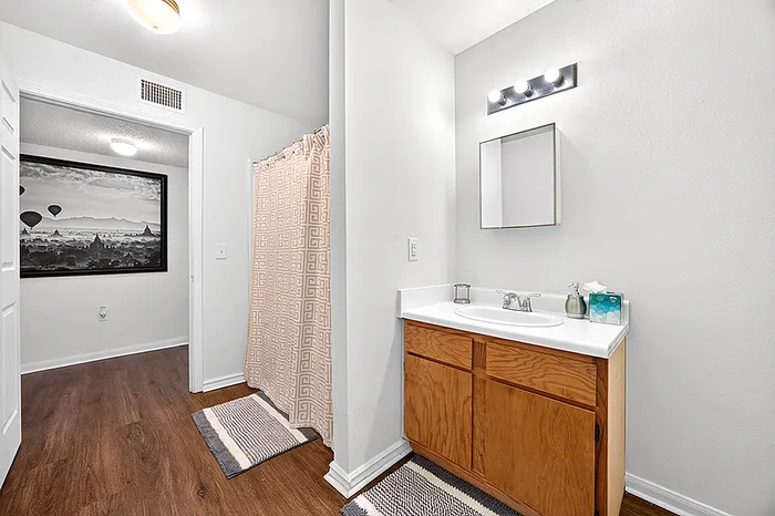 Modern bathroom featuring a sleek vanity with ample storage, stylish wall art, and elegant lighting fixtures.