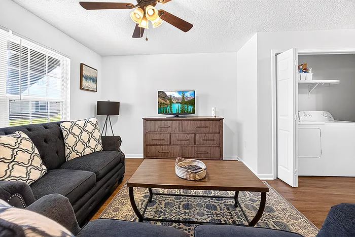 Inviting living room showcasing a plush dark sofa, elegant wood coffee table, and a cozy rug, complete with modern decor and natural light.