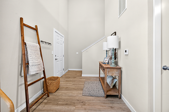 Inviting entryway with modern decor, featuring a cozy wooden ladder shelf, chic console table, and elegant lighting setup.