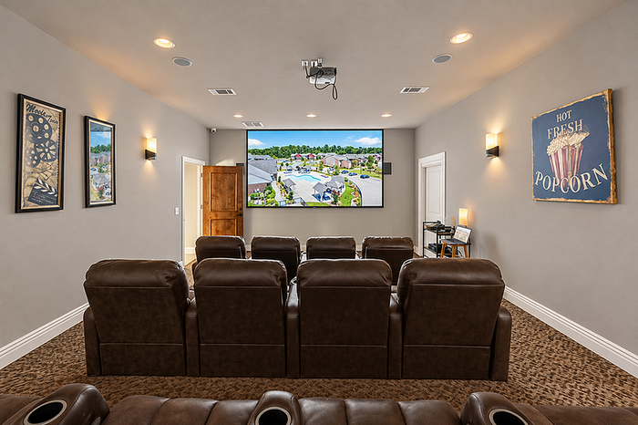 Luxurious home theater with plush reclining seats, expansive screen, and cozy lighting for the ultimate cinematic experience.