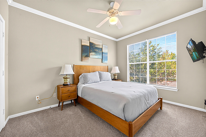 Inviting bedroom with elegant decor, large window for natural light, and cozy king-sized bed.