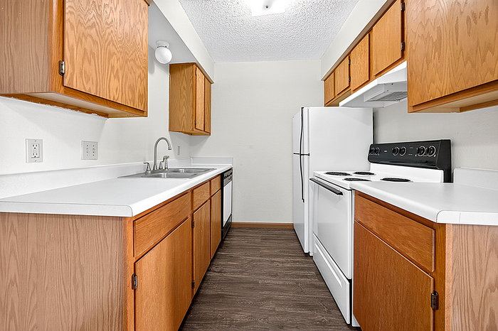 Modern kitchen with sleek white appliances, ample wooden cabinetry, and spacious countertops, perfect for culinary enthusiasts.