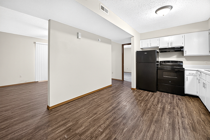 Modern open-concept kitchen with sleek appliances, rich wood flooring, and bright natural lighting.