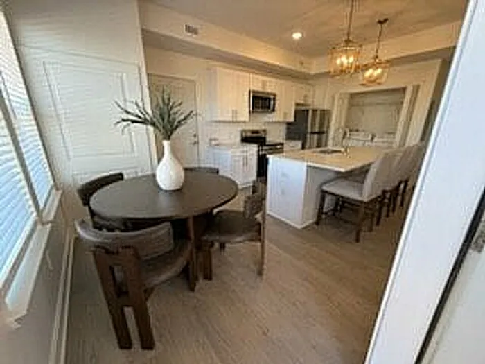 Elegant open kitchen and dining area with modern appliances, stylish lighting, and a cozy seating arrangement.