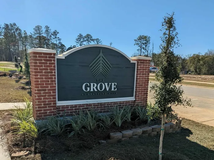 Inviting entrance sign of The Grove at Bradford Hills amidst a serene natural landscape.