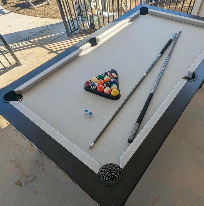 Elegant outdoor pool table setup with vibrant billiard balls and cues, perfect for entertaining and enjoying leisure time in style.