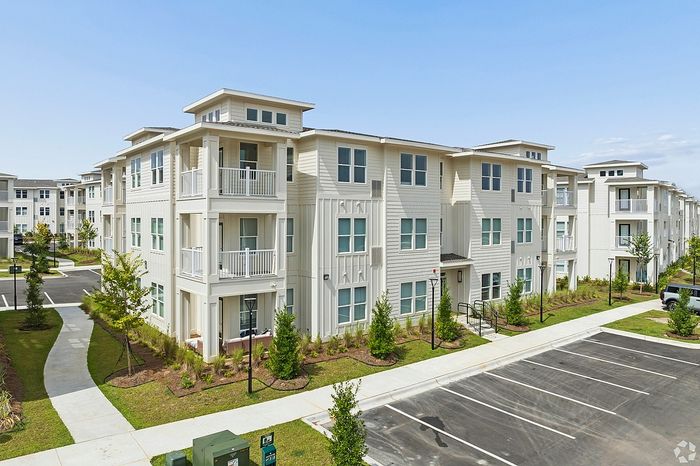 Beautiful modern apartment complex with attractive balconies, landscaped gardens, and ample parking space.