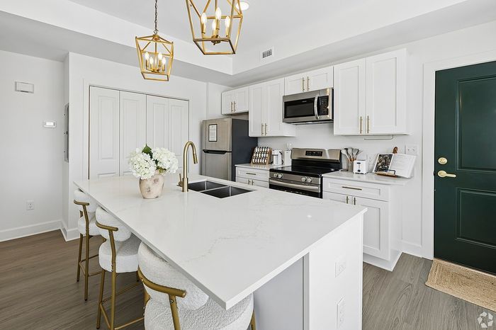 Elegant modern kitchen with sleek white cabinetry, quartz countertops, and gold accents, perfect for stylish living.