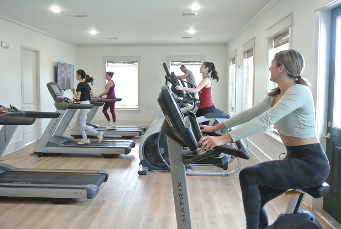 Bright and modern fitness center featuring state-of-the-art exercise equipment and large windows providing natural light.