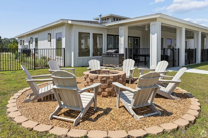 Chic outdoor living space with a cozy fire pit surrounded by Adirondack chairs, perfect for entertaining.
