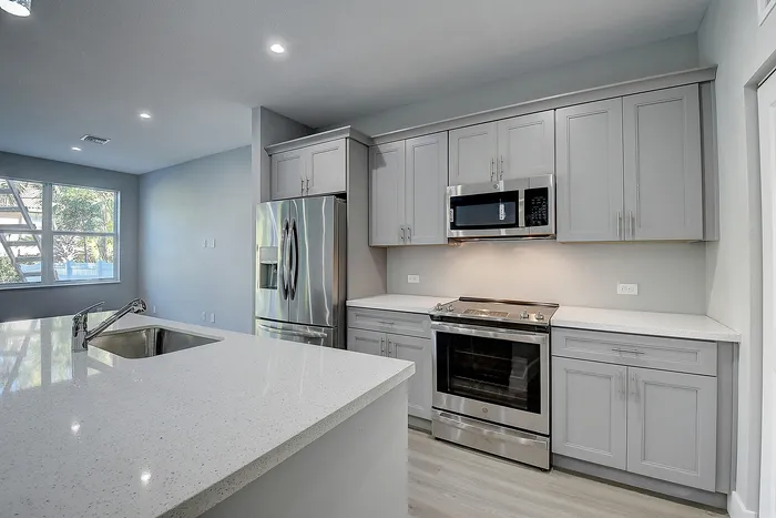Modern kitchen with sleek stainless steel appliances, elegant cabinetry, and a bright, spacious island countertop.
