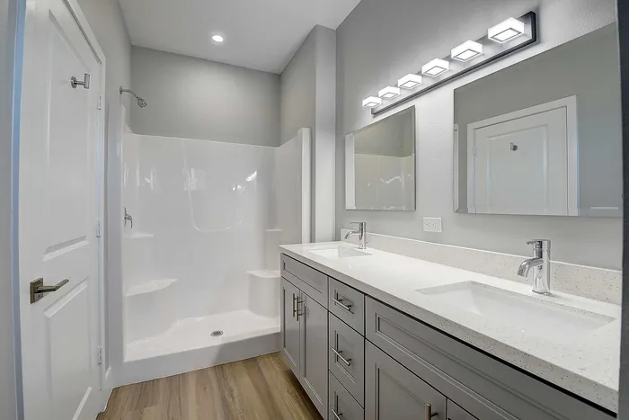 Elegant modern bathroom with dual sinks, sleek vanity, and bright lighting, perfect for a luxury apartment.