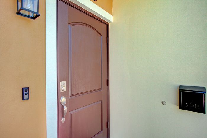 Inviting brown front door with modern doorbell and chic mailbox, enhancing the entrance's elegant style.