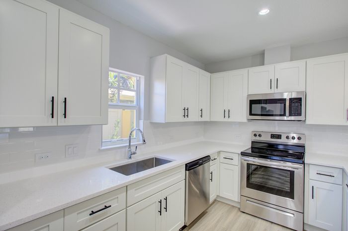 Modern kitchen with sleek white cabinets, stainless steel appliances, and a bright, airy atmosphere.