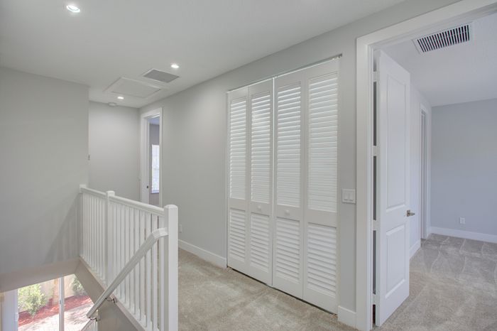 Bright and airy hallway with plush carpeting and stylish white doors, offering a glimpse into modern comfort.