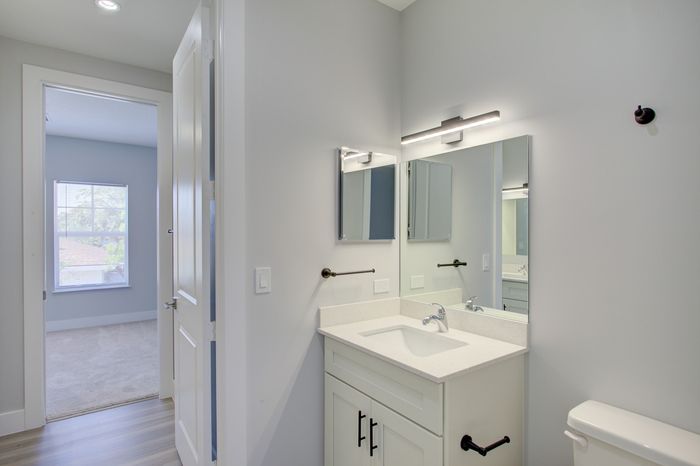Modern bathroom with sleek vanity and bright window view, offering refreshing natural light and elegant fixtures.