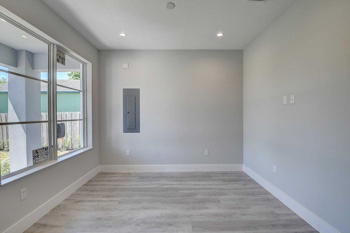 Bright, modern interior with sleek flooring, large window, and subtle recessed lighting.