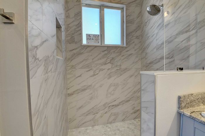 Elegant bathroom with luxurious marble tile walls and modern shower area.