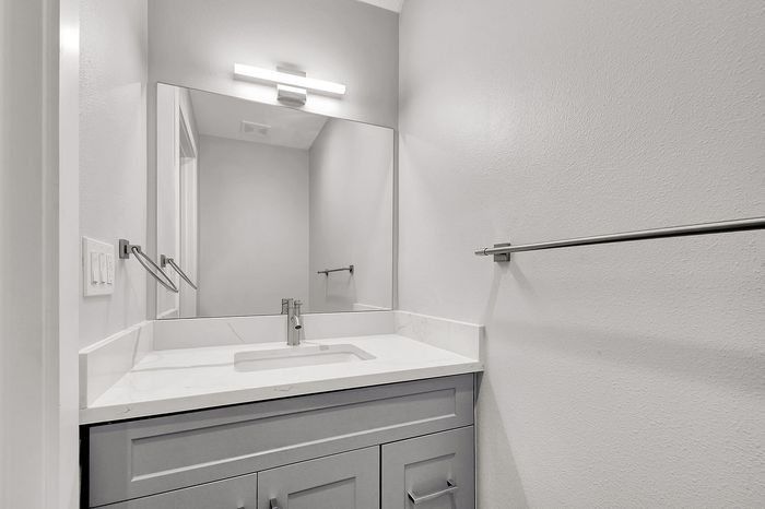 Sleek and modern bathroom vanity with a stylish marble countertop, contemporary lighting, and elegant silver fixtures.