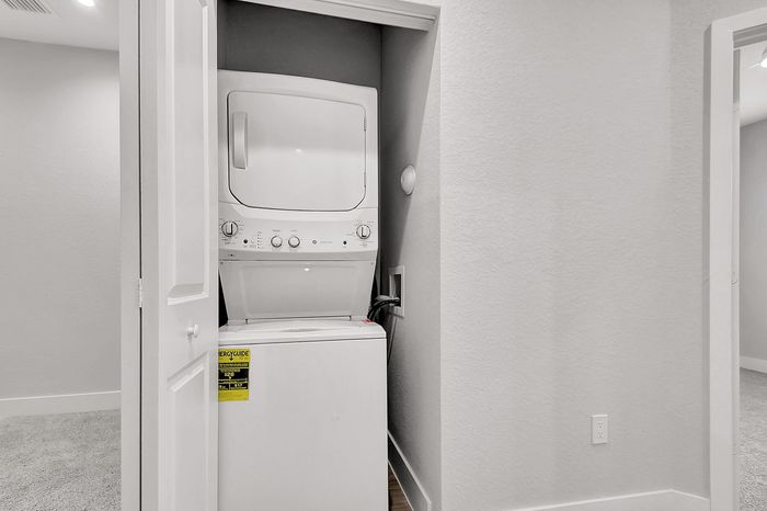 Modern apartment feature with convenient in-unit stacked washer and dryer in sleek, compact space.